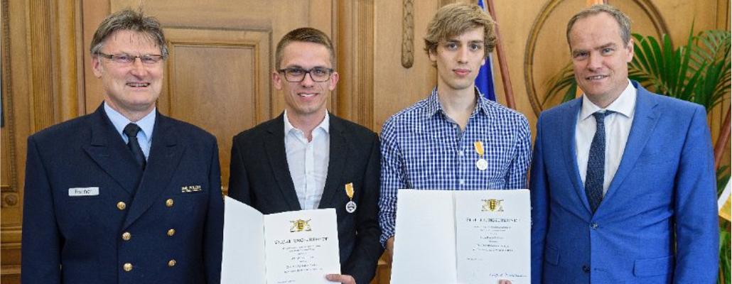 Oberbürgermeister Dr. Eckart Würzner (rechts) überreichte im Beisein von Peter Fischer (links), Leiter der Wasserschutzpolizei in Heidelberg, die Rettungsmedaille an Clemens Gudden (2. von links) und Marvin Bobrowski.